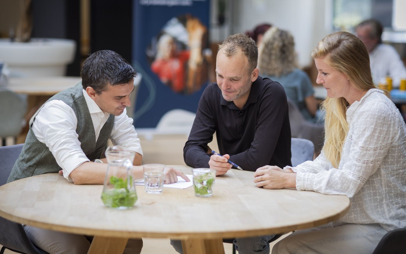 Ondernemer overlegt aan tafel over het moment om het team over de verkoop te vertellen