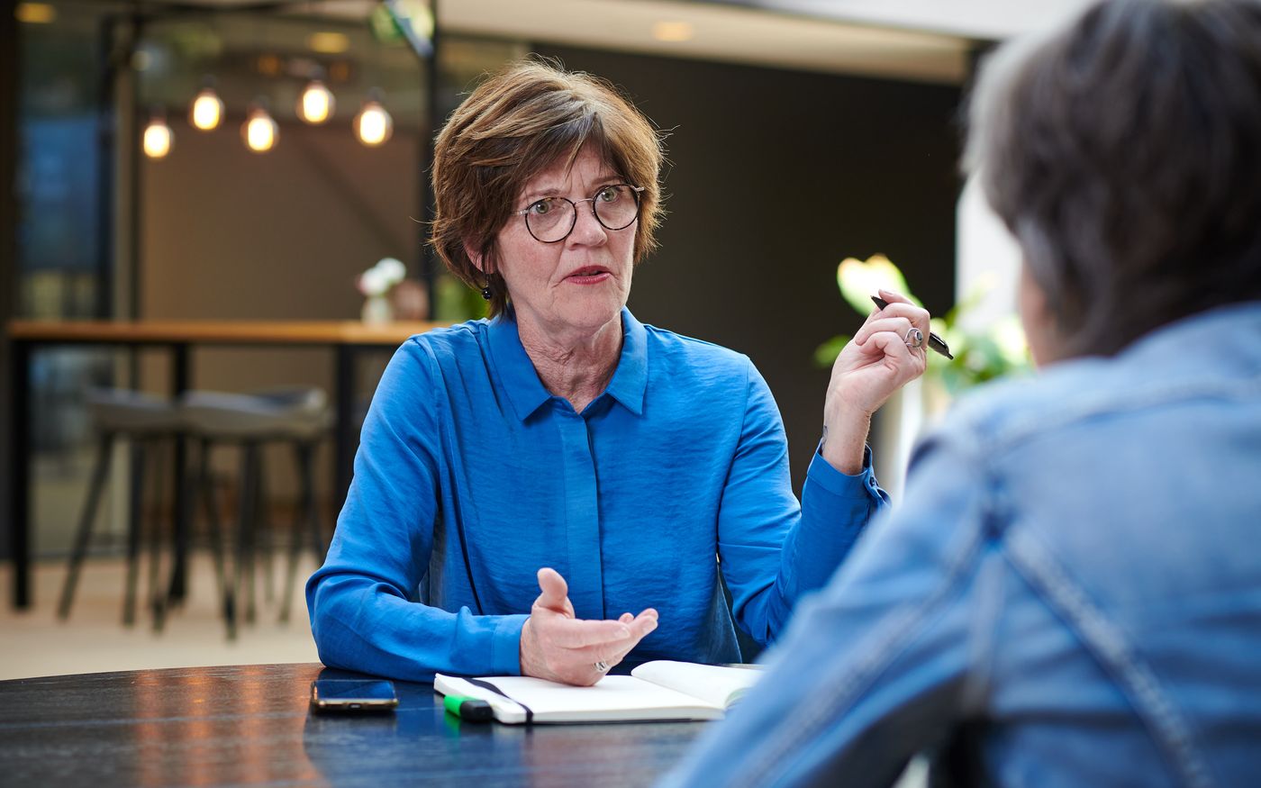 Ondernemer bespreekt aan tafel een STAK-constructie om medewerkers te laten meedelen